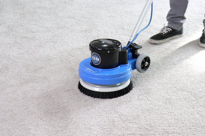 Floor cleaning machine on a concrete floor with a person partially visible.