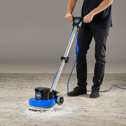Person using a prolux13  carpet cleaning machine on a carpeted floor.